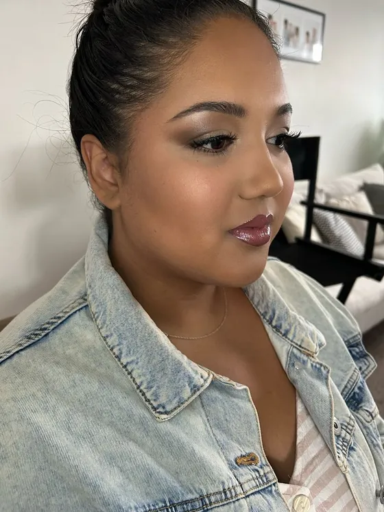 Berry-rose glossy lip with sculpted brows and a warm shimmer eye